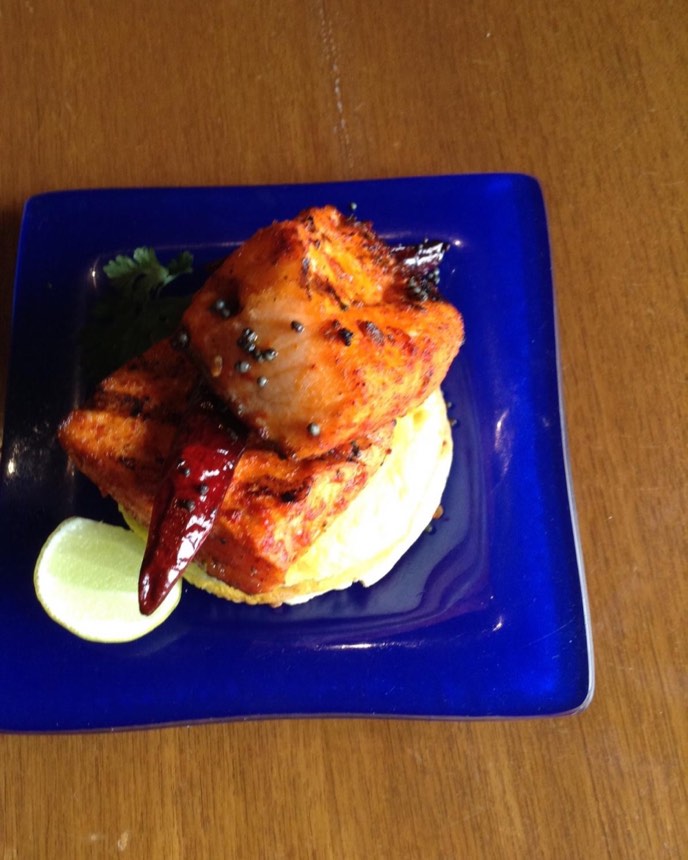 Char-grilled tandoori salmon on a blue plate